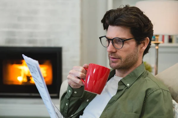 Muž Čtenářský Deník Zároveň Kávou Obývacím Pokoji Doma — Stock fotografie