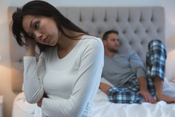 Angry couple avoiding each other in bedroom at home