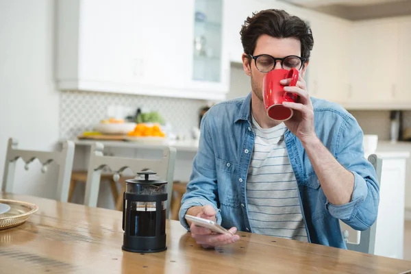 Homme Utilisant Téléphone Portable Tout Prenant Café Dans Cuisine Maison — Photo