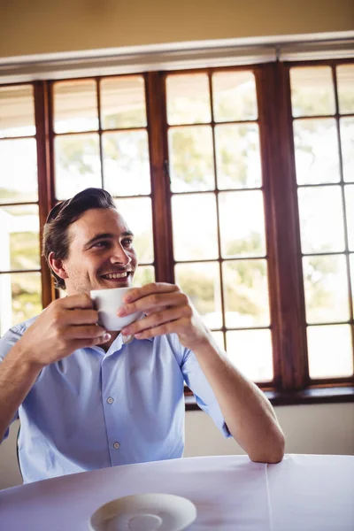 笑みを浮かべて男がレストランでコーヒーを飲んで — ストック写真