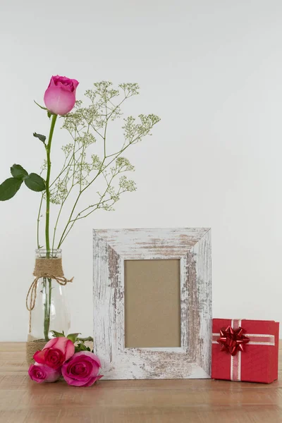 玫瑰花 空相框和礼品盒上的木桌 — 图库照片