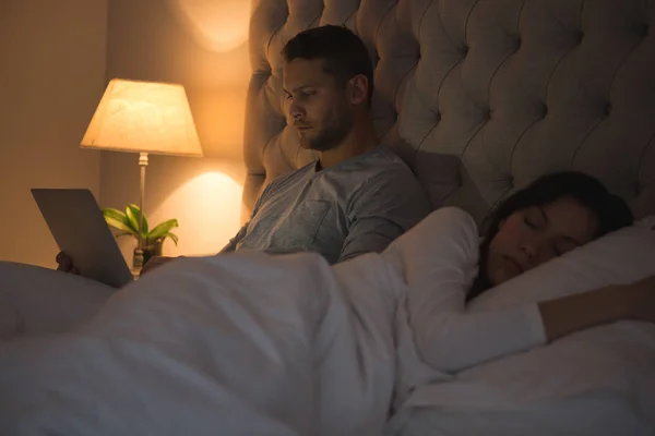Чоловік Використовує Ноутбук Коли Жінка Спить Спальні Вдома — стокове фото