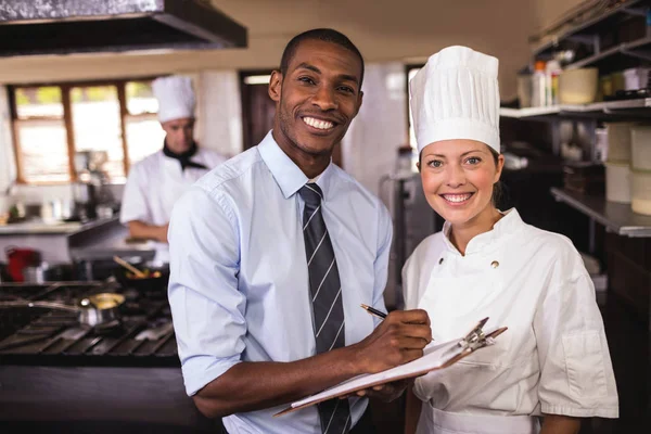 Male Manager Female Chef Writing Clipboard Kitchen Hotel — Stock Photo, Image