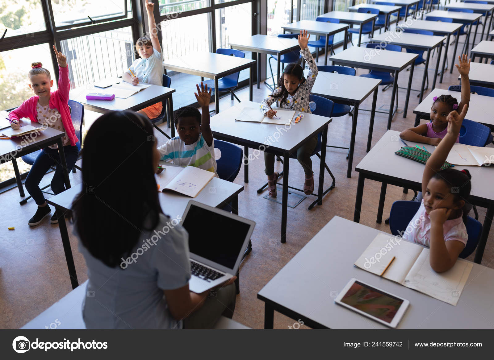 Visão Alto Ângulo Alunos Levantando Mãos Enquanto Sentados Mesa Sala — Foto  © Wavebreakmedia #241559742, image size:1600x1167