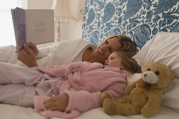 Vista Lateral Mãe Feliz Com Sua Jovem Filha Lendo Livro — Fotografia de Stock