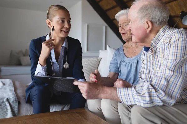 Front View Female Doctor Senior Couple Laughing Discussing Clipboard Hold — Stock Photo, Image