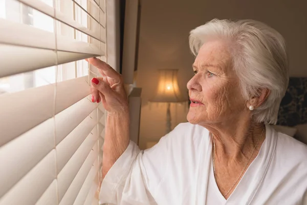 Side View Senior Woman Looking Window Blinds Home — Stock Photo, Image