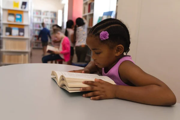 Side View Schoolgirl Reading Book Table School Library — стоковое фото