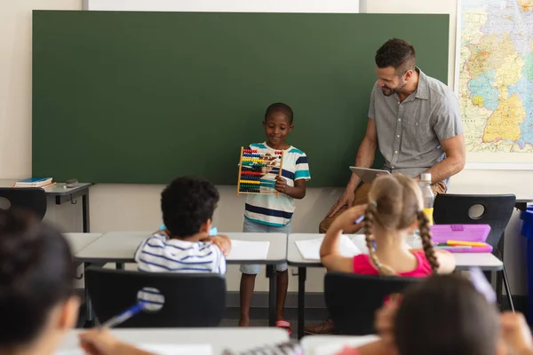 小学校の教室で数学そろばんを使用して黒の少年の正面図 — ストック写真