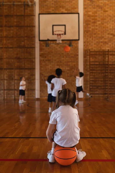 Kız Öğrenci Okulun Basketbol Sahası Basketbol Üzerinde Oturmak Arka Görünümü — Stok fotoğraf