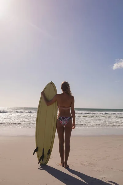 Achteraanzicht Van Vrouwelijke Surfer Permanent Met Surfboard Strand Kijken Naar — Stockfoto