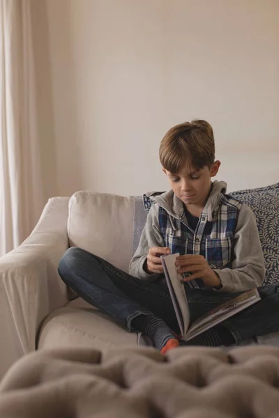 Вид Спереду Молодого Хлопчика Який Сидить Хрестом Дивані Читаючи Книгу — стокове фото