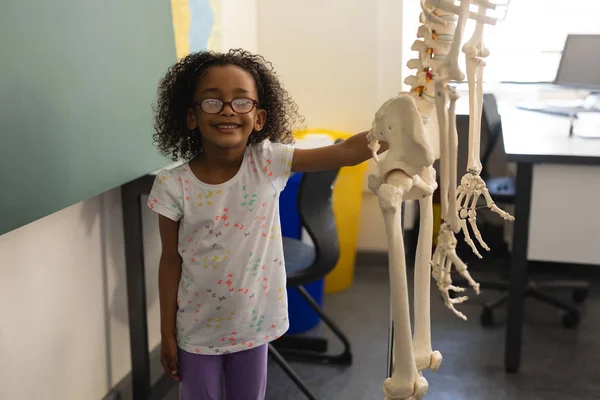 Vista Frontal Una Colegiala Negra Feliz Sosteniendo Modelo Esqueleto Humano —  Fotos de Stock