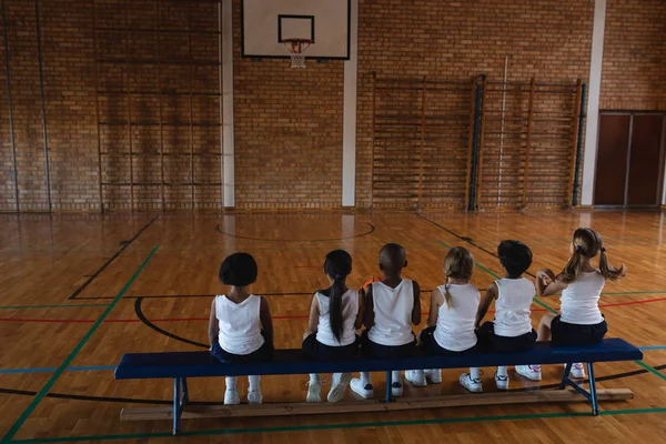 Οπίσθια Όψη Της Φορητούς Schoolkids Κάθεται Στον Πάγκο Στο Γήπεδο — Φωτογραφία Αρχείου