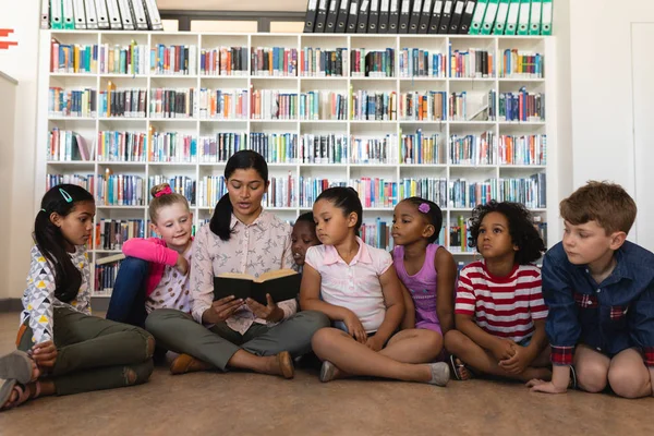 Vista Frontal Maestra Enseñando Los Escolares Sentada Piso Biblioteca Escolar — Foto de Stock