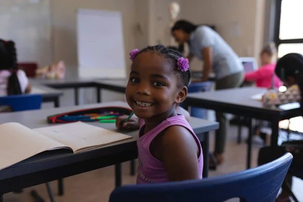 Rückseite Lächelnde Schülerin Sitzt Schreibtisch Und Blickt Die Kamera Klassenzimmer — Stockfoto