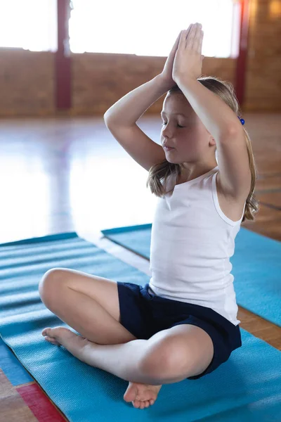 在学校里 女生在瑜伽垫上做瑜伽和冥想的侧视图 — 图库照片