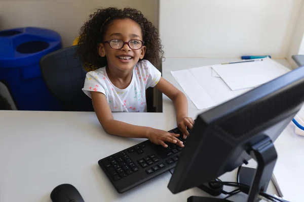 高角度表示ドイツの小学校の教室の机でデスクトップ を使用して小さな黒い女子高生 — ストック写真
