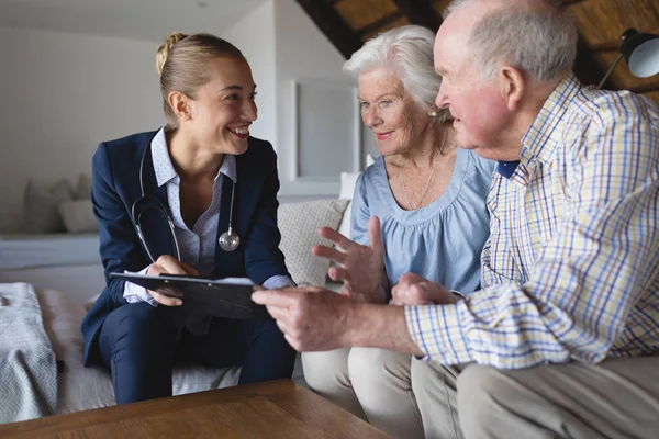 Front View Female Doctor Senior Couple Looking Discussing Clipboard Hold — Stock Photo, Image