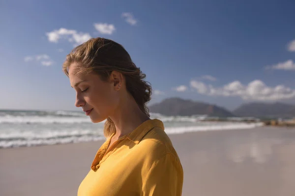 Νεαρή Γυναίκα Στέκεται Μάτια Κλειστά Στην Παραλία Μια Ηλιόλουστη Ημέρα — Φωτογραφία Αρχείου