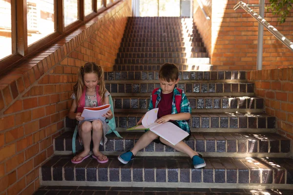 Vista Frontal Escola Caucasiana Ler Livro Enquanto Sentado Escadas Fora — Fotografia de Stock