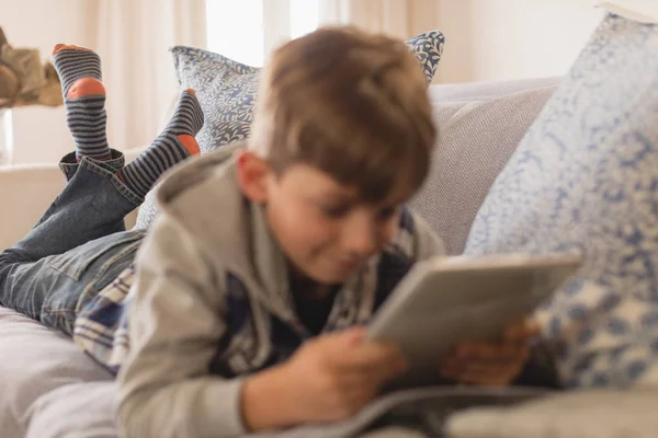 在家里的客厅里使用数字平板电脑时 关闭躺在前面的小男孩 — 图库照片