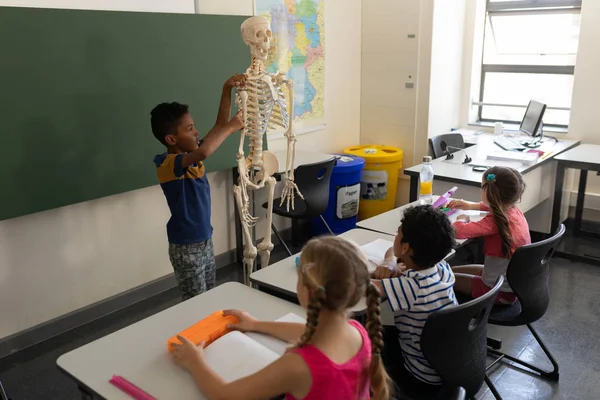 Vista Lateral Del Colegial Explicando Modelo Esqueleto Humano Aula Escuela —  Fotos de Stock