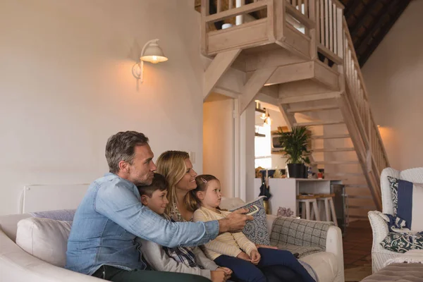 自宅のリビング ルームに飾られたスタイリッシュにテレビを見て一緒に時間を過ごす幸せな家族の側面図 — ストック写真