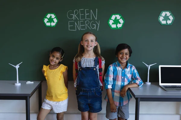 小学课堂上微笑的小学生站在绿色能源板的前面 — 图库照片