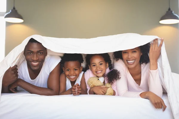 Framifrån Lycklig African American Familj Filt Och Titta Kameran Sängen — Stockfoto