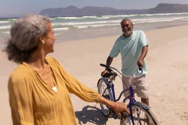 Feliz Pareja Ancianos Pie Con Bicicleta Mirando Uno Otro Playa —  Fotos de Stock