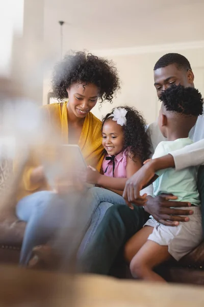 快適な家のソファの上デジタル タブレットを使用して かわいい子供連れの幸せなアフリカ系アメリカ人の正面図 — ストック写真