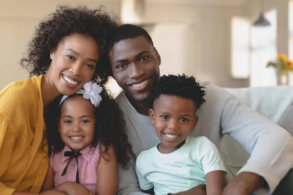 坐在沙发上 在舒适的家中看着快乐的非裔美国人家庭的正面景色 — 图库照片