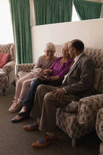 Vista Frontal Amigos Seniores Discutindo Sobre Tablet Digital Enquanto Sentados — Fotografia de Stock
