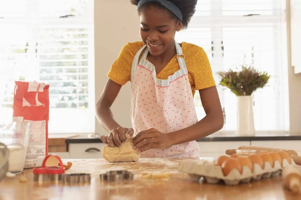 自宅のキッチンでクッキーを焼いてアフリカ系アメリカ人の少女の正面図 — ストック写真
