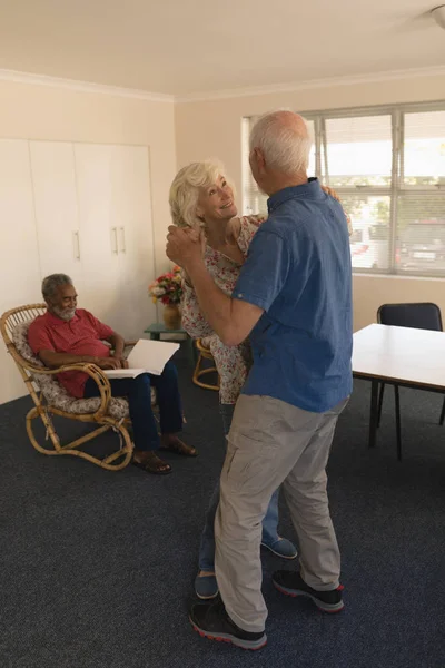 Side View Active Senior Couple Dancing Senior Man Reading Chair — Stock Photo, Image