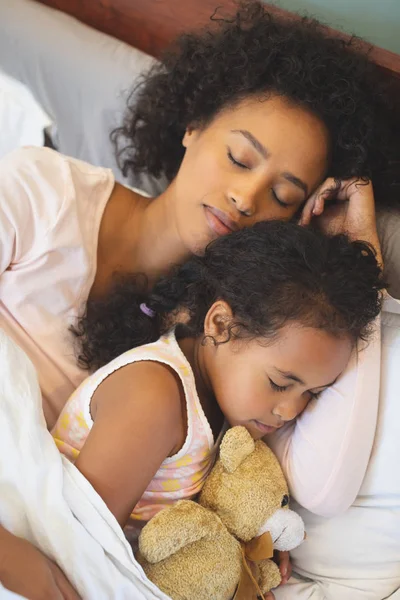 アフリカ系アメリカ人の母と自宅の寝室でベッドで一緒に寝ている娘のクローズ アップ — ストック写真