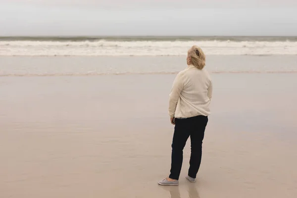 海のアクティブな幸せな先輩女立っている前面の背面図 — ストック写真