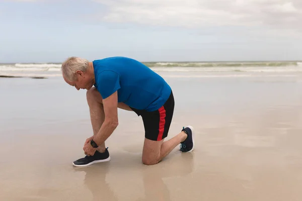 Vista Laterale Uomo Anziano Attivo Allacciatura Lacci Scarpa Spiaggia Con — Foto Stock