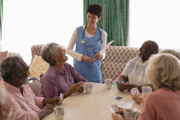 Vooraanzicht Van Vrouwelijke Arts Interactie Met Senior Mensen Terwijl Speelkaart — Stockfoto