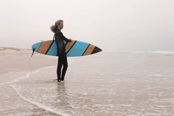 Widok Boku Starszych Kobiet Surfer Deski Surfingowej Stojący Plaży — Zdjęcie stockowe