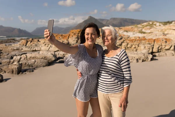 Vista Frontal Una Joven Feliz Tomando Selfie Con Madre Playa —  Fotos de Stock