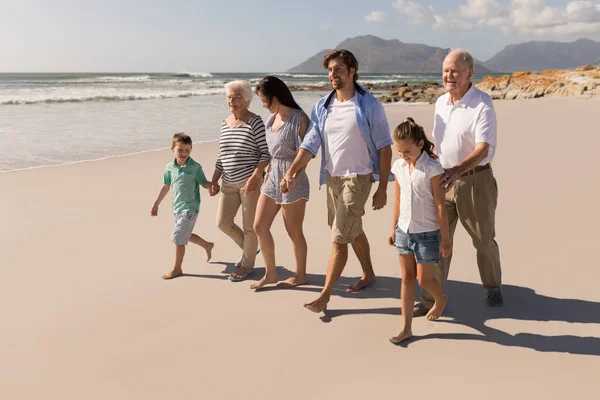 手を繋いでいると太陽の下 ビーチの上を歩く幸せな多世代家族の正面図 — ストック写真