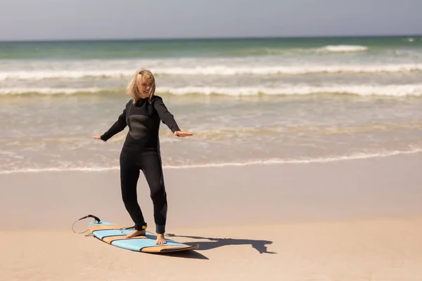 Zijaanzicht Van Actieve Senior Vrouwelijke Surfer Dansen Surfplank Strand — Stockfoto