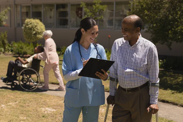 Vista Frontal Joven Doctora Feliz Discutiendo Informe Médico Con Hombre — Foto de Stock