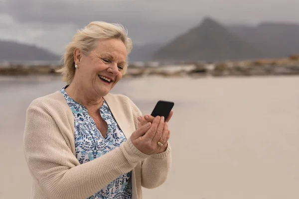 Вид Сбоку Активной Пожилой Женщины Мобильным Телефоном Стоящей Пляже Горами — стоковое фото