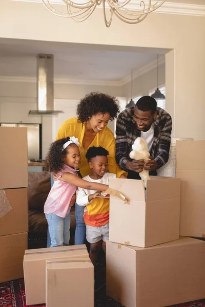 Mutlu Afro Amerikan Ebeveynlerin Çocuklarıyla Evde Oturma Odasında Eşyalarını Ambalaj — Stok fotoğraf