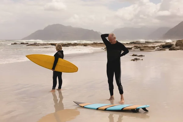 Front View Active Senior Couple Standing Surfboard Beach Mountains Background — Stock Photo, Image