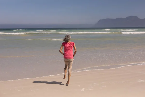 Vista Trasera Mujer Mayor Corriendo Playa Bajo Sol —  Fotos de Stock
