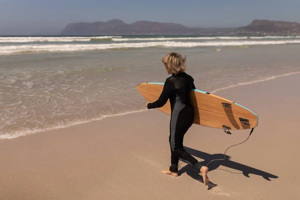 Widok Boku Aktywny Senior Surfera Kobiece Chodzenie Deski Surfingowej Plaży — Zdjęcie stockowe